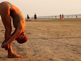 La niña calva yogui en la playa